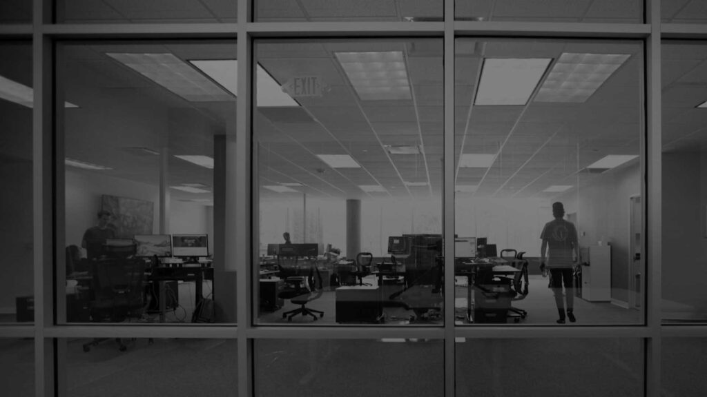 black and white photo of a workspace with people walking around