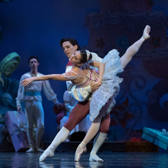 A male and female ballerina dancing together on a stage
