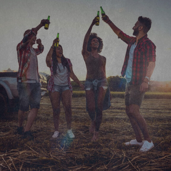Graphic of four people in a field raising their bottles of alcohol