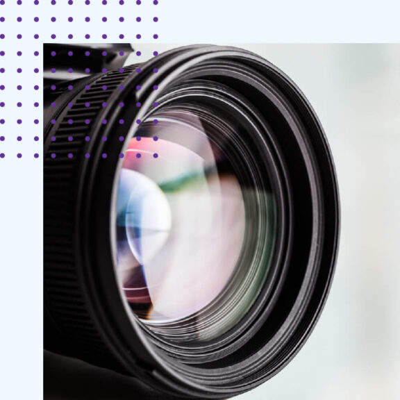 Zoomed in photo of a camera lens and a purple dotted icon in the top left corner of the image