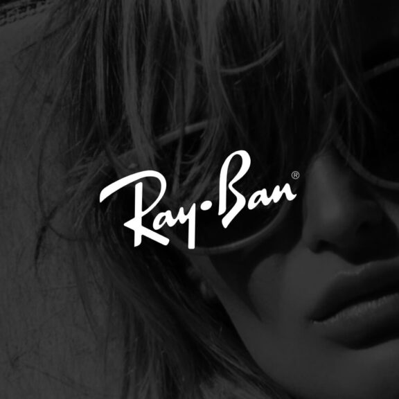 Photo of a girl wearing sunglasses with a black filter on the image and a white Ray-Ban logo in the center of the image
