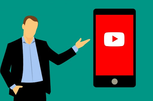 Green graphic featuring an illustration of a man in a suit pointing towards a black smartphone with the YouTube app loading on it's screen